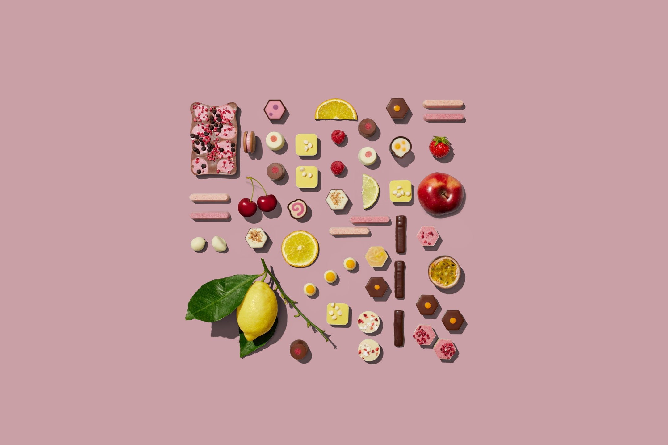 Chocolate and fruity ingredients laid out on a flat surface, arranged in the shape of a square.